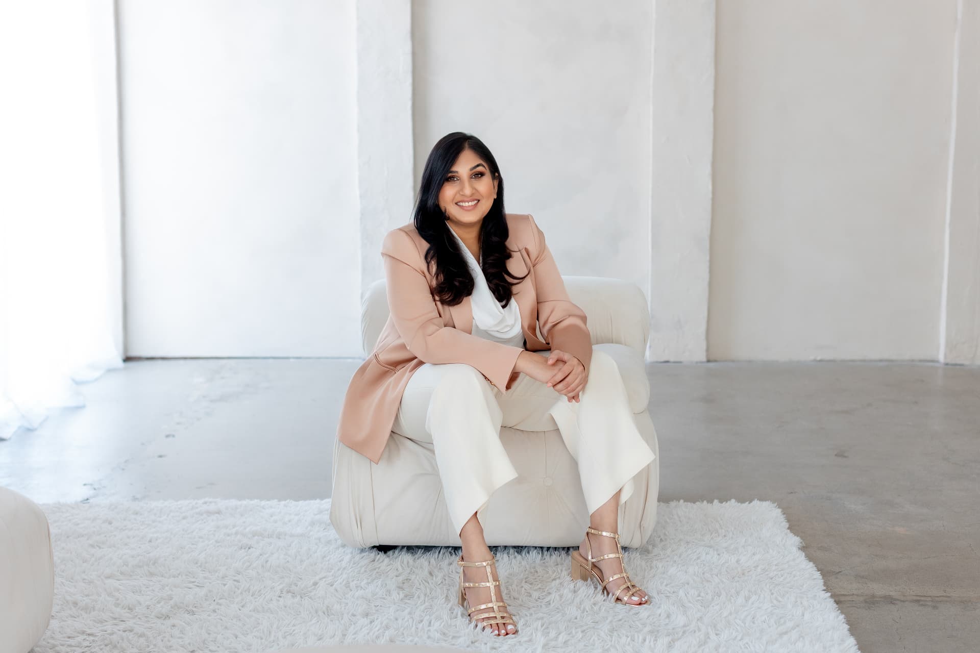 Pari, founder of the New Earth Leaders Collective, seated in a bright cream studio